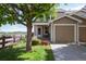 Inviting home with a charming front yard, lush lawn, lovely flowers, and an attached single-car garage at 2296 E 109Th Dr, Northglenn, CO 80233