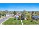 Aerial view of a home with a lush green lawn, mature trees, and a well-maintained neighborhood at 1400 S Knox Ct, Denver, CO 80219