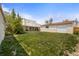 Expansive backyard featuring lush lawn, detached garage, and mature tree landscaping at 1400 S Knox Ct, Denver, CO 80219