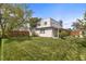 Backyard with a lush lawn, covered patio, and wood fence at 1400 S Knox Ct, Denver, CO 80219