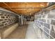 Unfinished basement shows concrete floor, concrete block wall, and open wood beam ceiling at 1400 S Knox Ct, Denver, CO 80219