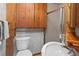 Cozy bathroom with wooden cabinets, a walk-in shower, and a charming vanity at 1400 S Knox Ct, Denver, CO 80219