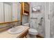 Cozy bathroom featuring wood vanity, toilet, medicine cabinet, and shower at 1400 S Knox Ct, Denver, CO 80219