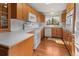 Well-lit kitchen featuring wood cabinets, a white countertop and white appliances at 1400 S Knox Ct, Denver, CO 80219