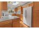 Classic kitchen featuring wood cabinets, white appliances, and a charming skylight at 1400 S Knox Ct, Denver, CO 80219