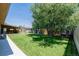 Expansive backyard featuring lush lawn, mature tree, playset, covered patio with bar, and storage shed at 9170 Aspen Dr, Thornton, CO 80229
