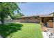Spacious backyard with lush lawn, brick exterior, patio with counter, and mature trees offering shade at 9170 Aspen Dr, Thornton, CO 80229