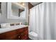 Clean bathroom shows vanity, a decorative mirror, and shower behind a white curtain at 9170 Aspen Dr, Thornton, CO 80229
