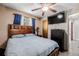 Well-lit bedroom showcases wood-framed bed, ceiling fan, and dresser with a television at 9170 Aspen Dr, Thornton, CO 80229