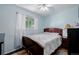 Bright bedroom featuring wood flooring, large window, and wood-framed bed with soft linens at 9170 Aspen Dr, Thornton, CO 80229