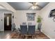 Elegant dining area features a glass table, modern chairs, wood floors, and sophisticated decor at 9170 Aspen Dr, Thornton, CO 80229