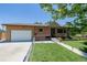 Welcoming single-story home with brick accents, green lawn, and attached garage at 9170 Aspen Dr, Thornton, CO 80229