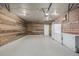 Finished garage featuring epoxy flooring, wood-paneled walls, freezer, and an insulated door at 9170 Aspen Dr, Thornton, CO 80229