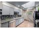 Well-lit kitchen featuring granite counters, grey cabinetry, stainless steel appliances, and sleek backsplash at 9170 Aspen Dr, Thornton, CO 80229