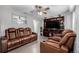 Cozy living room features reclining leather sofas, ceiling fan, and large entertainment center at 9170 Aspen Dr, Thornton, CO 80229