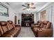 Comfortable living room featuring reclining leather furniture, ceiling fan, and custom built-in shelving at 9170 Aspen Dr, Thornton, CO 80229
