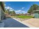 Fenced backyard with a lush lawn, large trees and a concrete patio for entertaining at 5556 Vaughn St, Denver, CO 80239