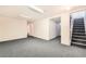 Finished basement with gray carpet, access to stairs, and fresh paint at 5556 Vaughn St, Denver, CO 80239
