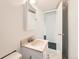 Bathroom with single sink vanity, mirror, and access to bedroom at 5556 Vaughn St, Denver, CO 80239