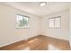 Bright bedroom featuring hardwood floors, two windows, and light neutral walls at 5556 Vaughn St, Denver, CO 80239