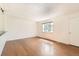 Spacious living room featuring polished hardwood floors, white walls, and bright natural light at 5556 Vaughn St, Denver, CO 80239