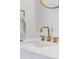 Modern bathroom close-up showing gold fixtures, round mirrors, and stone countertops at 2430 Eaton St, Edgewater, CO 80214