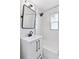 Bathroom with white tiled shower, framed mirror, and sleek fixtures for a modern aesthetic at 2430 Eaton St, Edgewater, CO 80214