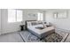 Bright bedroom has a modern rug, a gray bed with blue pillows, and multiple windows at 2430 Eaton St, Edgewater, CO 80214