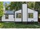 Charming home with black and white exterior and chimney, surrounded by a lush green lawn at 2430 Eaton St, Edgewater, CO 80214