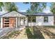 Charming renovated home with a modern wood-paneled garage door and manicured lawn at 2430 Eaton St, Edgewater, CO 80214
