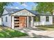 Charming renovated home with a modern wood-paneled garage door and manicured lawn at 2430 Eaton St, Edgewater, CO 80214