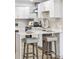 Modern kitchen features breakfast bar with stylish stools, stainless appliances, and sleek white cabinetry at 2430 Eaton St, Edgewater, CO 80214