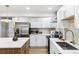 Bright kitchen boasts stainless steel appliances, white cabinets, and a large island with stone countertops at 2430 Eaton St, Edgewater, CO 80214