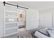 Main bedroom suite featuring a sliding barn door to the ensuite bathroom at 2430 Eaton St, Edgewater, CO 80214