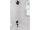 Close up of shower featuring black fixtures and white subway tile for a clean, modern look at 2430 Eaton St, Edgewater, CO 80214