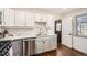 Modern kitchen with white cabinets, stainless steel appliances, and a view into living room at 4481 W 89Th Way, Westminster, CO 80031