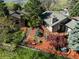 Aerial view showcasing the house, large yard with mature trees, water feature, and lush landscaping at 837 Meadow Run, Golden, CO 80403