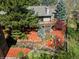 Overhead view of the backyard, featuring an elevated deck, lush landscaping, colorful mulch, and mature trees at 837 Meadow Run, Golden, CO 80403