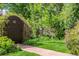 Charming backyard pathway leading to a gate surrounded by lush greenery at 1795 N Monaco St Pkwy, Denver, CO 80224