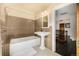 Well-maintained bathroom with tiled walls, a pedestal sink, and a shower-tub combination at 1795 N Monaco St Pkwy, Denver, CO 80224