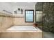 Bright bathroom features a jacuzzi tub, glass shower, and tiled walls at 1795 N Monaco St Pkwy, Denver, CO 80224