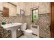 Charming bathroom with designer tile, classic fixtures, and stained glass window at 1795 N Monaco St Pkwy, Denver, CO 80224