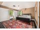 Bedroom with built-in shelving, windows with white shutters, and a colorful rug at 1795 N Monaco St Pkwy, Denver, CO 80224