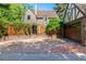 Front of a brick home showing the driveway and detached garage with a Tudor-style design at 1795 N Monaco St Pkwy, Denver, CO 80224