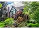 Beautifully landscaped home with a stone facade, mature trees, and colorful foliage at 1795 N Monaco St Pkwy, Denver, CO 80224