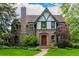Charming Tudor-style home with a stone facade, arched entryway, and a beautifully landscaped front yard at 1795 N Monaco St Pkwy, Denver, CO 80224