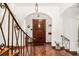 Elegant foyer with terracotta tile flooring, arched entryway, and an ornate wrought iron railing at 1795 N Monaco St Pkwy, Denver, CO 80224