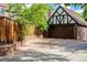 Detached garage with a Tudor-style design, wooden doors, and a circular driveway at 1795 N Monaco St Pkwy, Denver, CO 80224