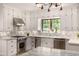 Bright kitchen features white cabinets, stainless steel appliances, and light countertops at 1795 N Monaco St Pkwy, Denver, CO 80224