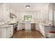 Bright, white kitchen with marble countertops, stainless steel appliances, and hardwood floors at 1795 N Monaco St Pkwy, Denver, CO 80224